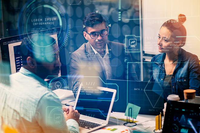 Three professionals having a discussion in a modern office setting with digital data graphics overlaid on the image.